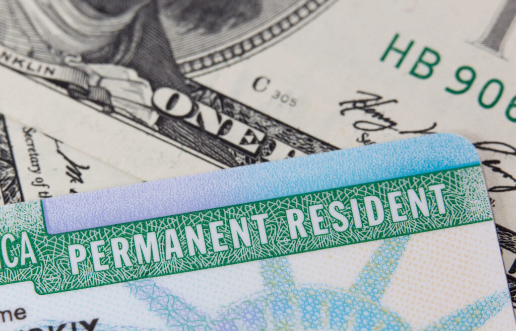dollars and permanent resident card close up